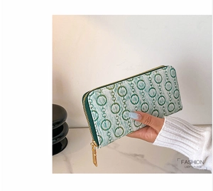 Detail of long PU leather wallet with green chain pattern and gold zipper closure