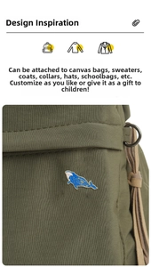 Starry sky whale enamel brooch pinned on an olive green canvas bag showing decorative detail