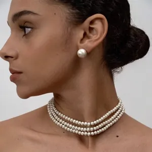 Collier de perles à trois rangs avec boucles d'oreilles assorties sur un mannequin