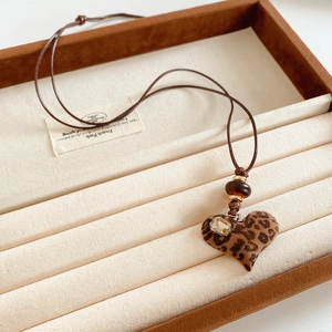 Détail du pendentif cœur léopard avec pierre rectangulaire et perles de résine brunes