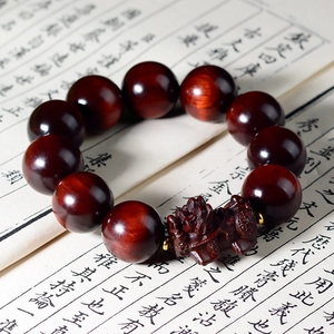 Dettaglio del bracciale Pixiu in legno rosso intagliato su calligrafia tradizionale