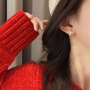 Elegant gold reindeer stud earrings with crystal inlay worn by a female model