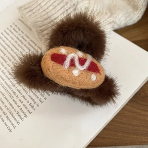 Detailed fuzzy hot dog hair claw clip with wool felt bread and sausage on an open book