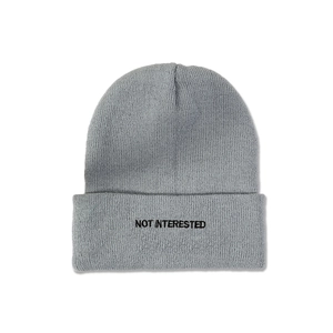 Macro detail of NOT INTERESTED black embroidery on gray ribbed knit beanie cap