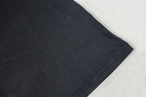 Detail view showing the fine stitching and high-quality fabric texture of the black dress