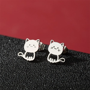Macro detail of silver cat-shaped stainless steel stud earrings with cute engraved faces