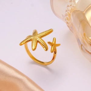 Golden starfish open ring with sea elements and textured finish on elegant satin background