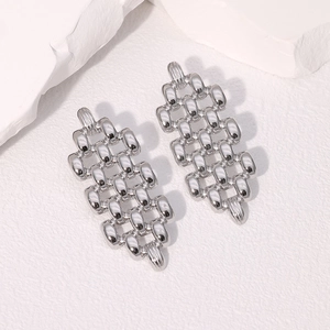 Vue détaillée de boucles d'oreilles géométriques en chaîne tressée argentée sur pierre