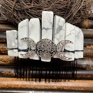 Macro shot of boho hair comb featuring raw white stones and silver triple moon emblem