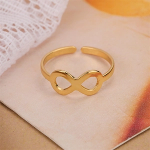 Primer plano de un anillo abierto de infinito dorado sobre fondo de textura