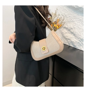 Detail of stylish beige crescent bag with weave texture and gold twist lock clasp