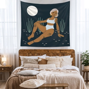 Modern bohemian tapestry featuring female illustration hanging above a bedroom headboard