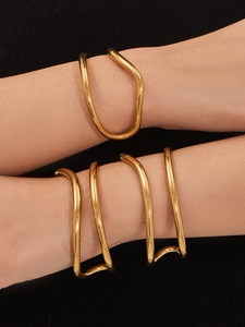 Dettaglio del bracciale rigido irregolare a C placcato oro 18k e polsino a spirale