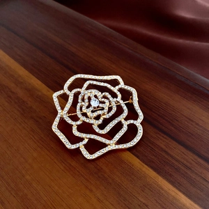 Vue détaillée d'une broche rose vintage dorée ornée de cristaux étincelants