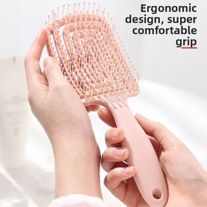 Pink curved detangling brush with ball-tipped bristles for scalp massage and hair styling