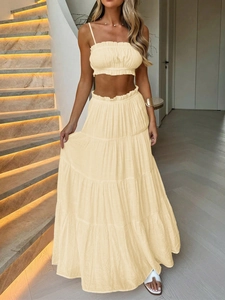 Detailed view of beige two-piece set featuring a bandeau top and layered maxi cake skirt