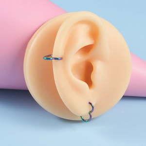 Créoles en forme de cœur en acier inoxydable arc-en-ciel sur modèle d'oreille