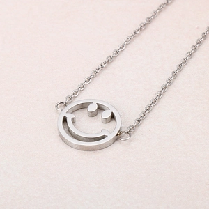 Macro detail of polished stainless steel bracelet featuring a minimalist hollow smiley face