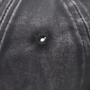 Close-up of vintage washed gray cotton baseball cap with embroidered eyelet detail