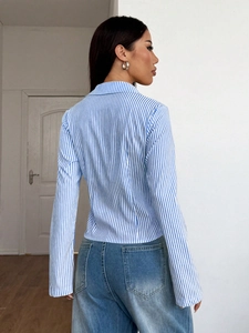 Women's chic blue and white striped lapel shirt seen from back view with slim fit cut