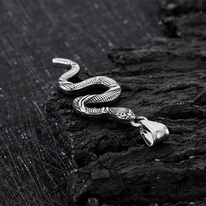 Macro detail of a vintage silver stainless steel snake pendant showing scale textures