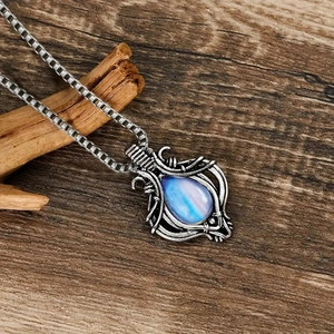 Vintage ketting met blauwe druppelhanger en zilveren boxketting op houten achtergrond
