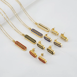Détail de parures en acier inoxydable doré avec pendentifs rectangulaires en strass