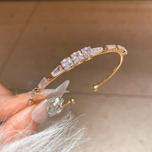 Detail view of 18K gold plated open bracelet with sparkling square-cut cubic zirconia