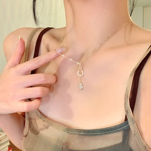 Détail du collier gourde plaqué or avec incrustations de zircon et pendentif jade blanc