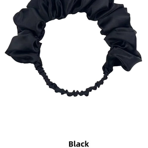 Detailed view of the elastic satin hairband with glossy brown pleated fabric texture