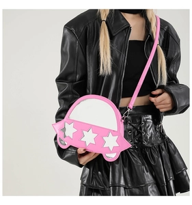 Sac bandoulière rose en forme de voiture avec détails d'étoiles porté par un mannequin