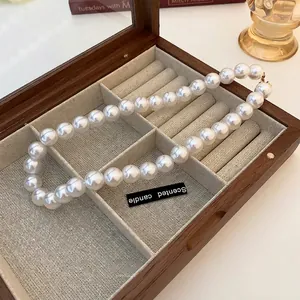 French vintage style large pearl necklace displayed in a luxury wooden jewelry box