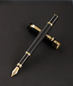 Detail of professional black and gold fountain pen with textured barrel and 18K nib