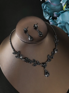 Detail view of sparkling black crystal flower necklace and teardrop earrings set