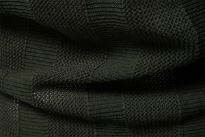 Macro shot of dark green stripe textured knit fabric showing detailed weaving patterns