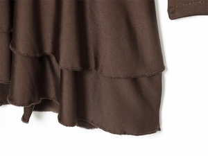 Close-up of layered ruffle hem on coffee brown casual dress with fine stitching