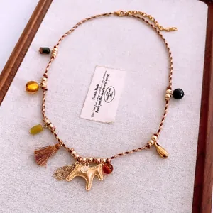 Ethnic woven rope necklace with golden dog pendant, colorful beads and silk tassels