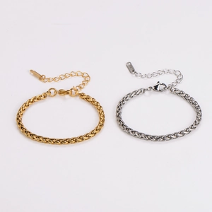 Flat lay of wheat chain bracelets in gold and silver finishes with lobster clasp detail