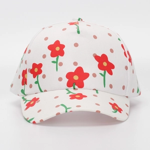 Detailed view of white cotton baseball cap with red flower prints and brown polka dots