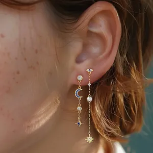 Macro view of s925 sterling silver star moon tassel earrings with evil eye motif