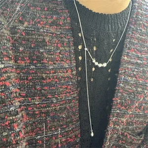 Detailed view of 925 sterling silver Y-shaped beaded necklace on model in elegant outfit