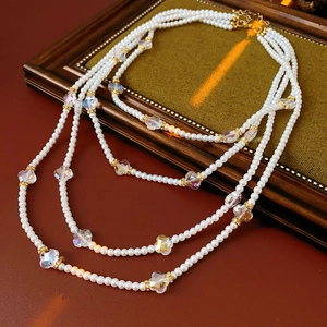 Détail de collier de perles multicouche avec accents floraux sur cadre vintage