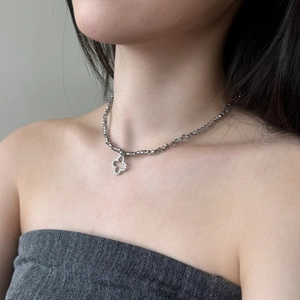 Detail of S925 silver necklace featuring crystal beads and clover pendant on a model