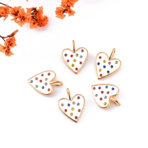 Golden heart pendants with white enamel and colorful crystals on white background