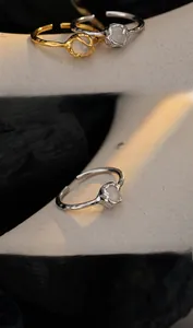 Detail of S925 silver adjustable ring with white agate bead on charcoal texture background