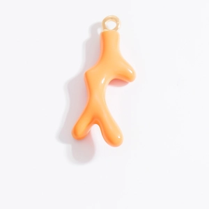 Détail d'un pendentif branche de corail orange avec anneau doré pour bijoux DIY