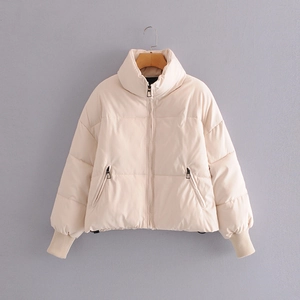 Short beige padded jacket with stand collar and side zip pockets on a hanger