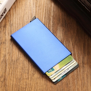 Blue metal RFID card holder on a wooden desk showing the card ejection mechanism
