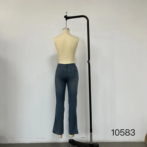 Detailed view of high waisted blue jeans with back pockets and subtle distressed wash