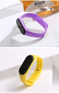 Detail view of purple and yellow LED sports wristbands with silicone straps and black dials
